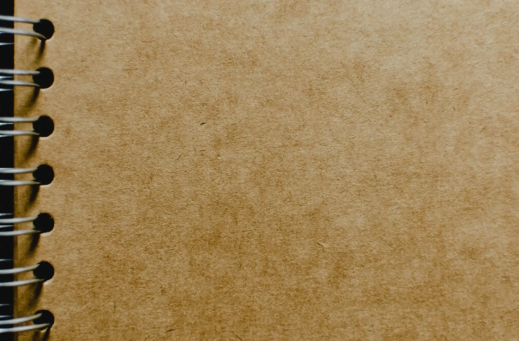 Detailed close-up of a spiral notebook with a focus on the kraft paper cover texture, ideal for design mockups.