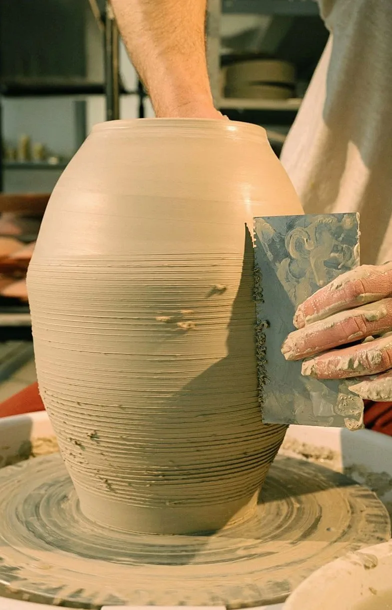 A skilled artisan molding a clay pot on a pottery wheel, showcasing traditional craftsmanship.
